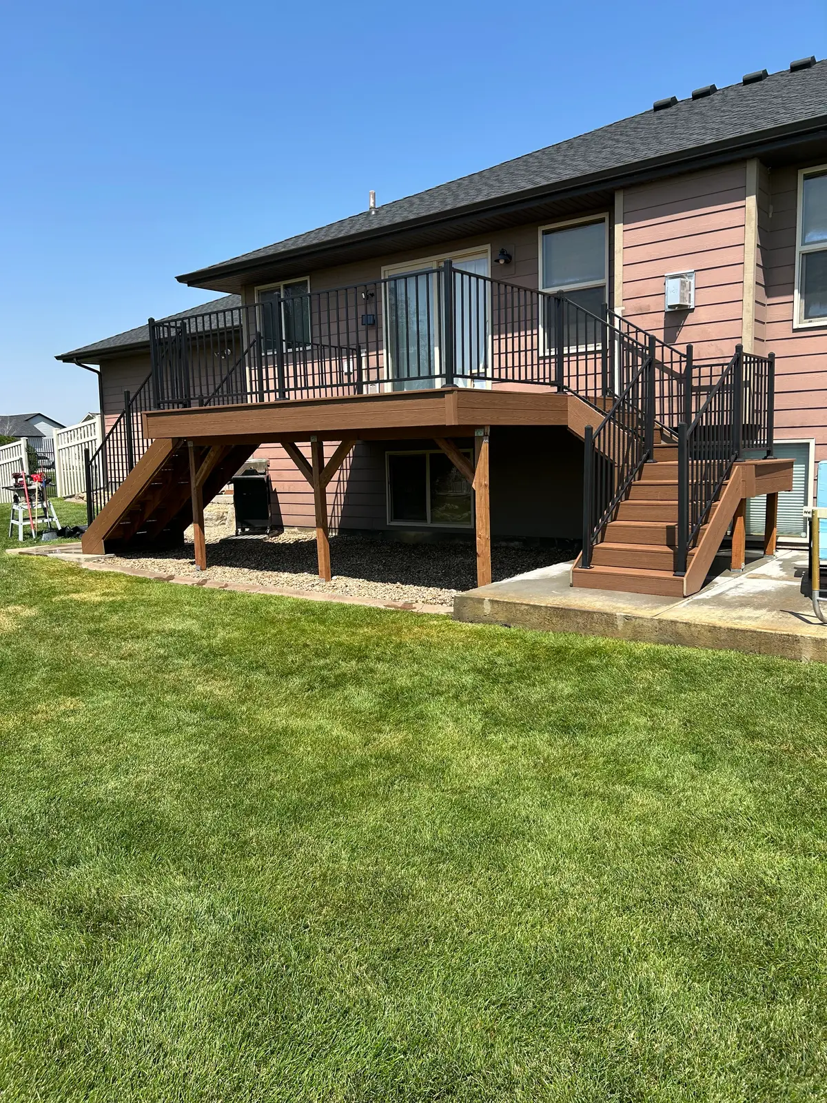 Composite deck stairs down to a concrete patio